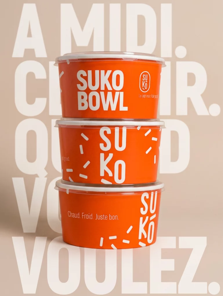 Trois bols de nourriture Suko à emporter, avec packaging orange.